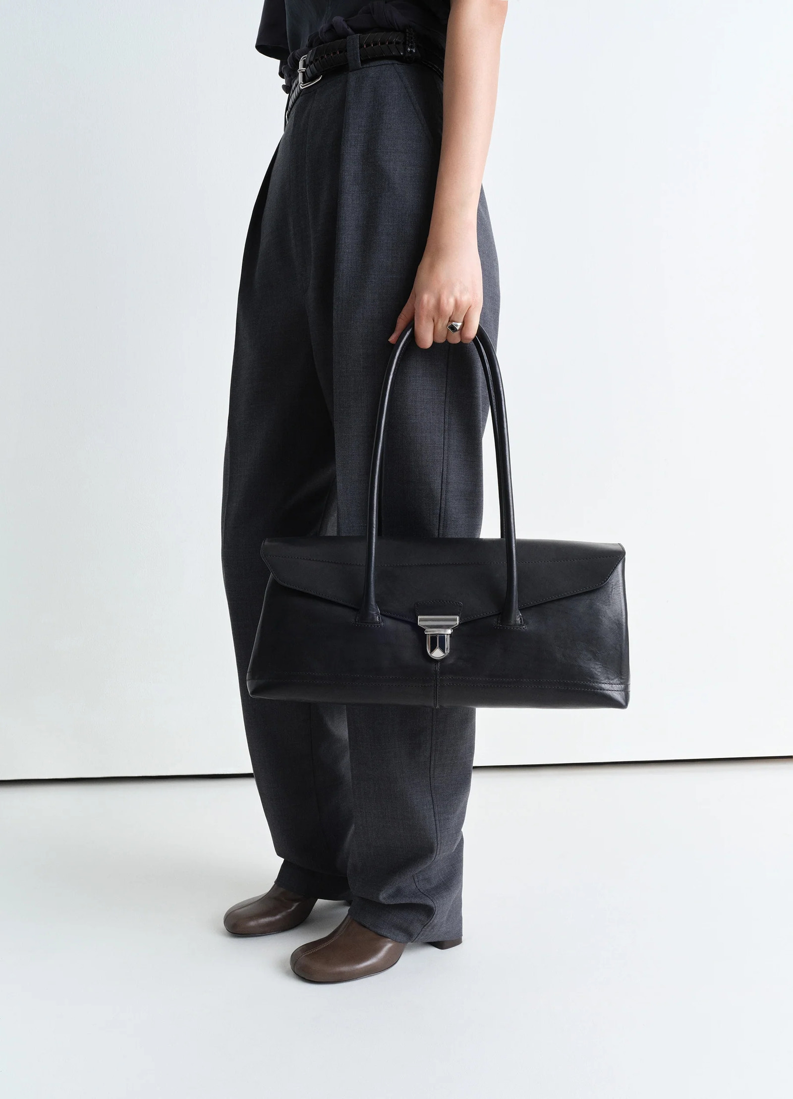 Lemaire shoulder gear bag in black vegetable tanned nappa, model shot, side view vintage-inspired