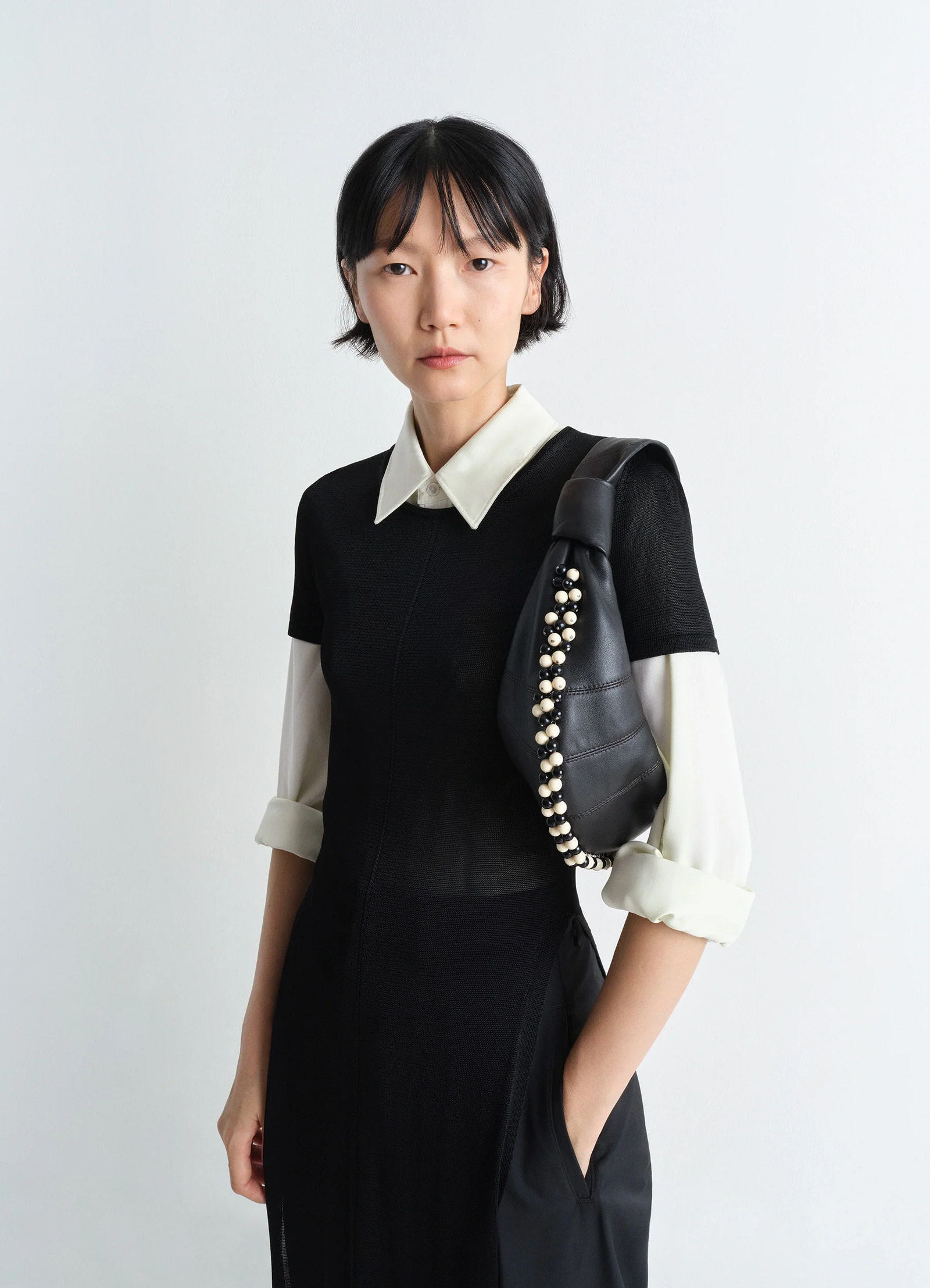 Mini fortune bag with beads in soft nappa lamb leather, model shot, front view short handle worn on shoulder