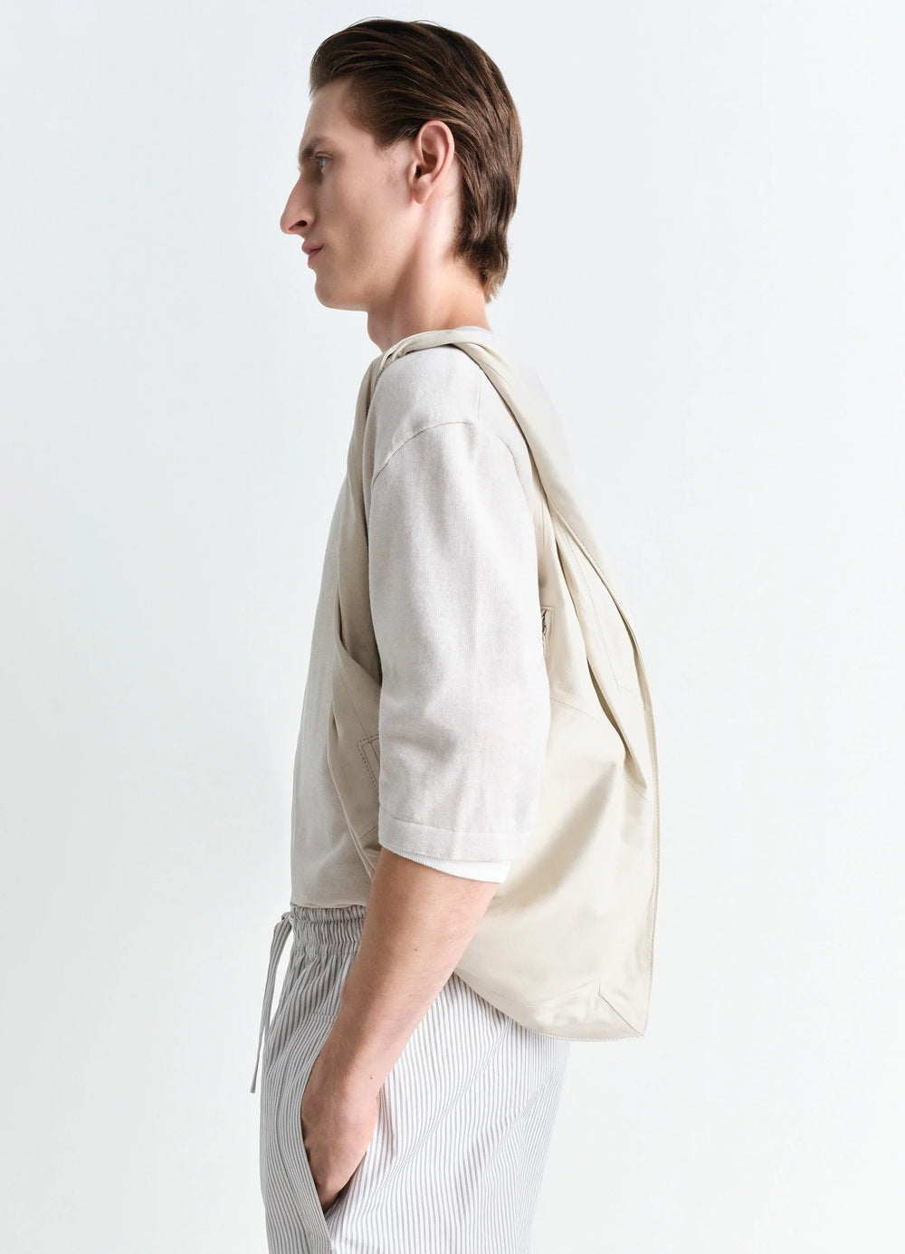 Lemaire Scarf Bag Small in Smooth Nappa Leather, model shot, profile view over shoulder carry