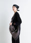 Lemaire Scarf Bag in nappa leather, model shot, side view twisted shoulder strap