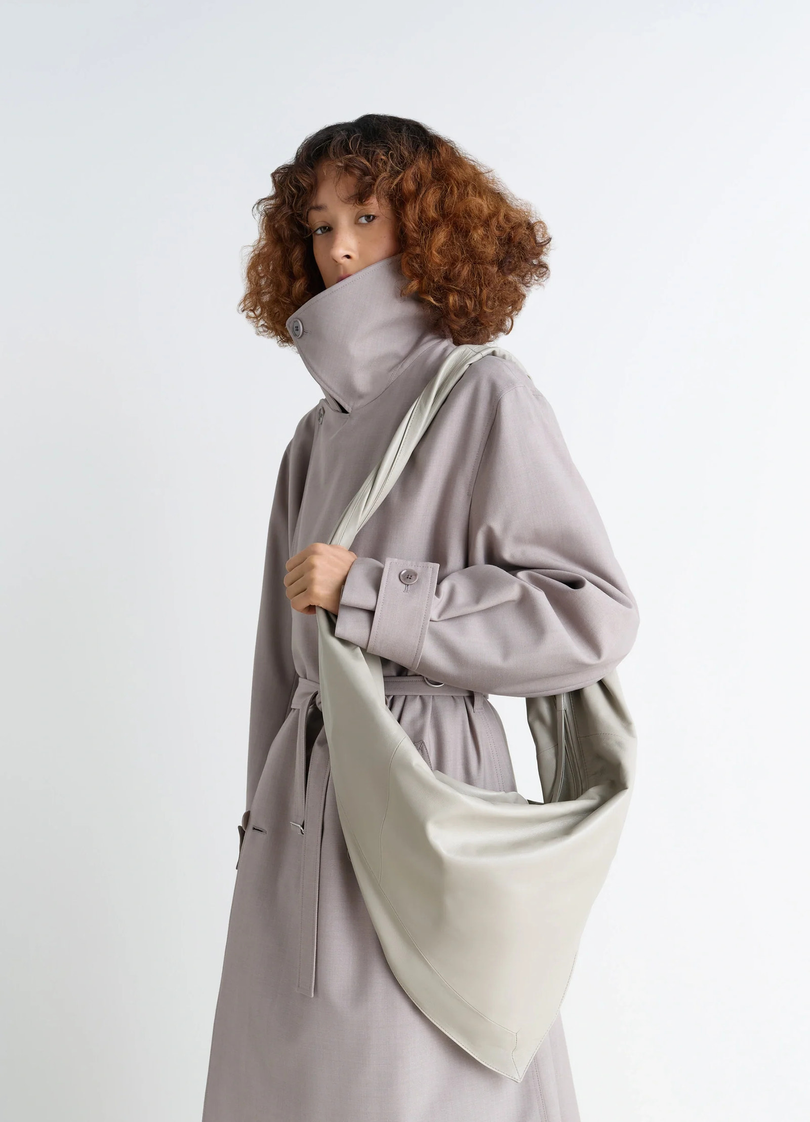Lemaire scarf bag in nappa leather, model shot, side view twisted shoulder strap