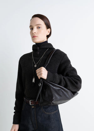 Belted Baguette Bag in Shiny Paper Lux Leather, model shot, Front detail view Minimalist utilitarian style