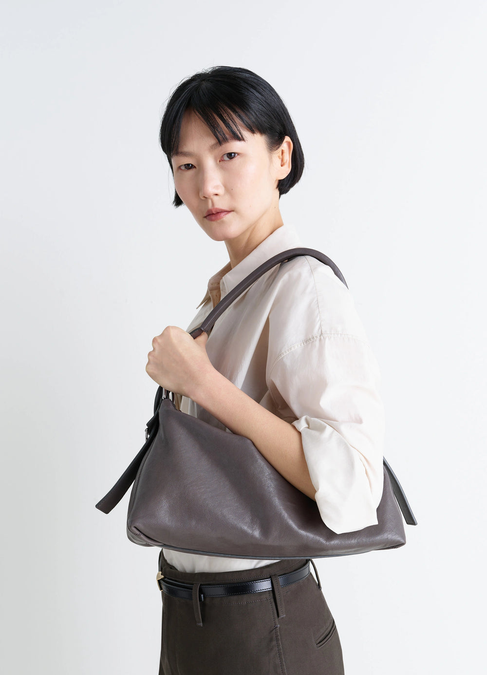 Belted Baguette Bag in Paper Lux Leather, model shot, over shoulder view rolled sleeve shirt