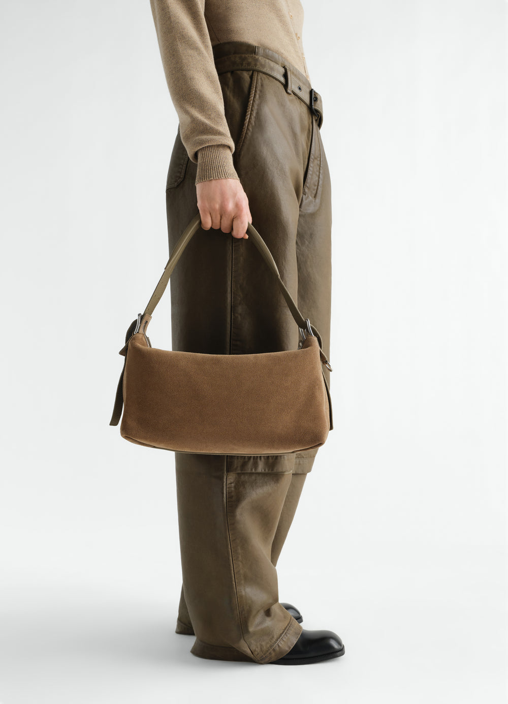 Belted baguette bag in brown suede leather LEMAIRE worn by model side view with leather trousers