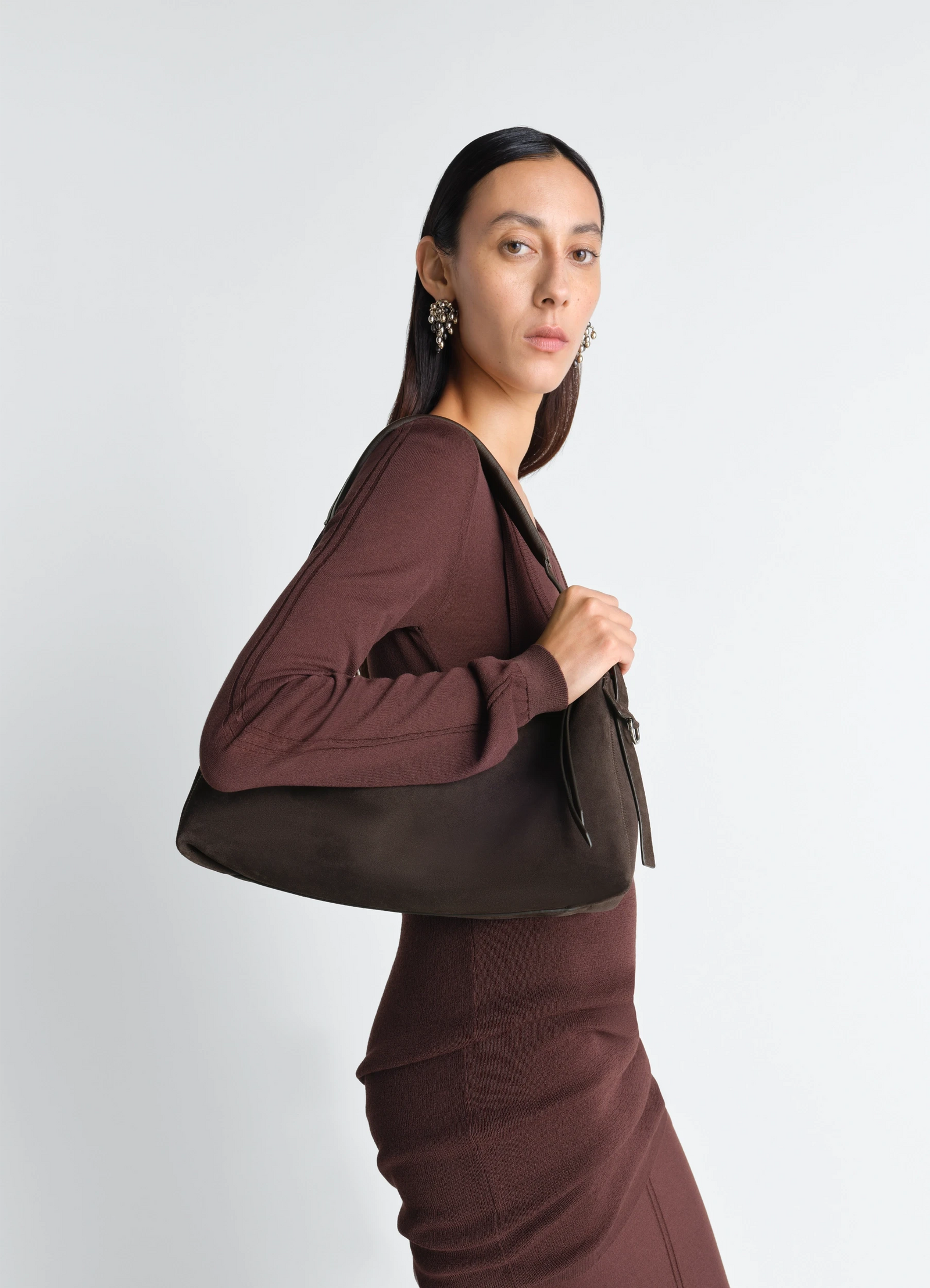 Belted baguette bag in suede leather, model shot, side view shoulder carry