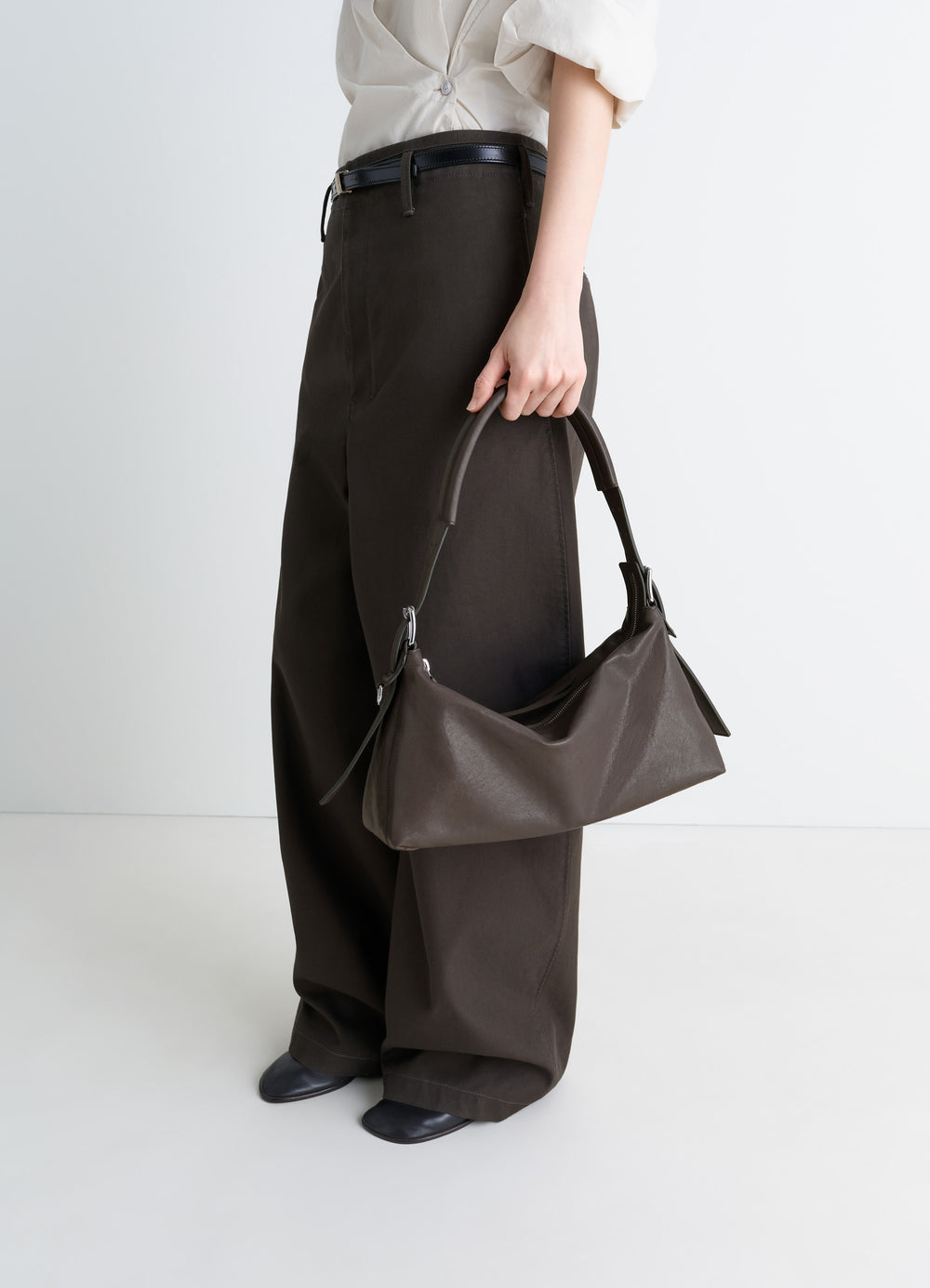 Belted Baguette Bag in Paper Lux Leather, model shot, Side view Wide leg pants