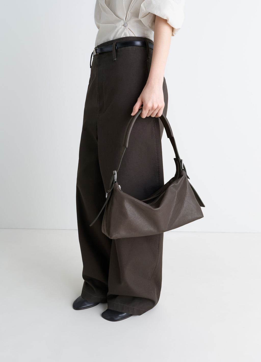 Belted Baguette Bag in Paper Lux Leather, model shot, Side view Wide leg pants