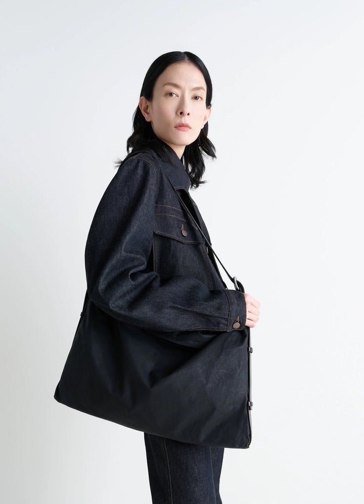 Trench Pocket Medium Bag in Black Resinated Cotton Canvas, model shot, Side view Utilitarian design