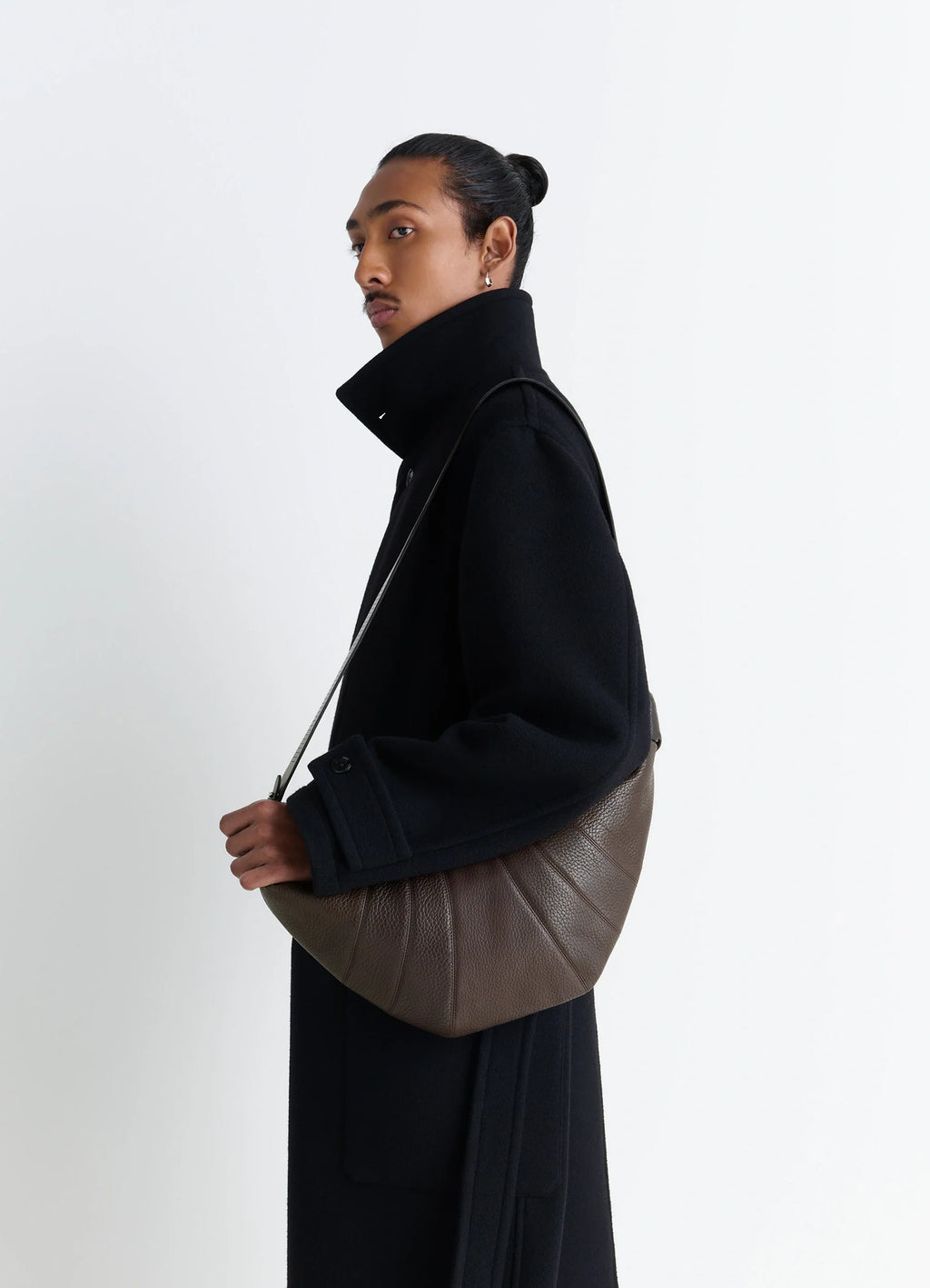 Rail Belt Medium Croissant Bag in Grained Leather in Brown, model shot, Side view Curved design with shoulder strap