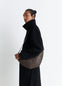 Rail Belt Medium Croissant Bag in Grained Leather in Brown, model shot, Side view Curved design with shoulder strap