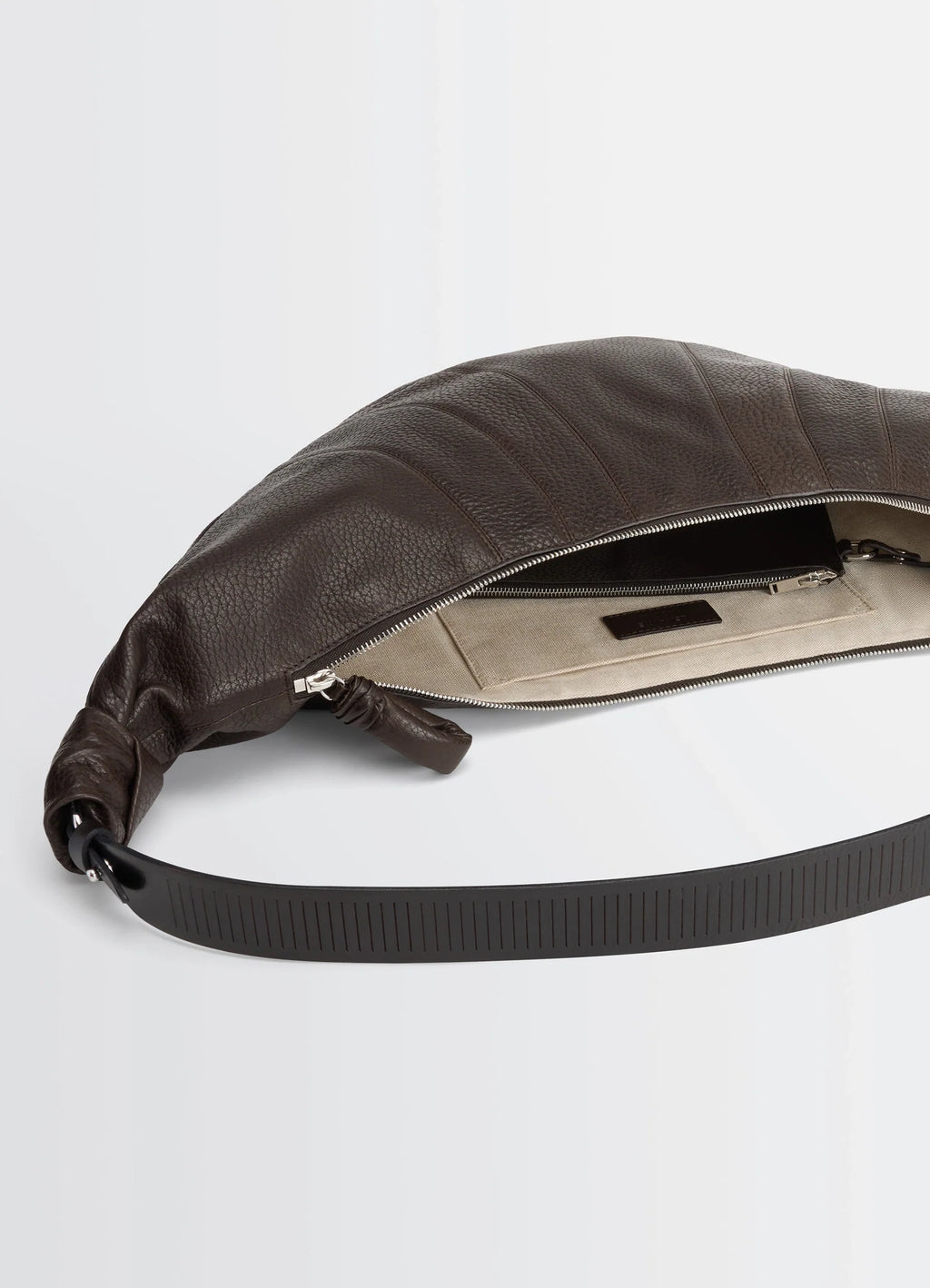 Lemaire Rail Belt Large Croissant B in Grained Leather, product shot, top angle view exposed zipper design