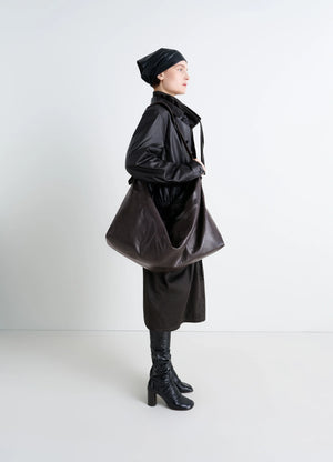 Berlingot 72H Weekend Bag in Glazed Paper Leather, model shot, Side view Minimalist and versatile