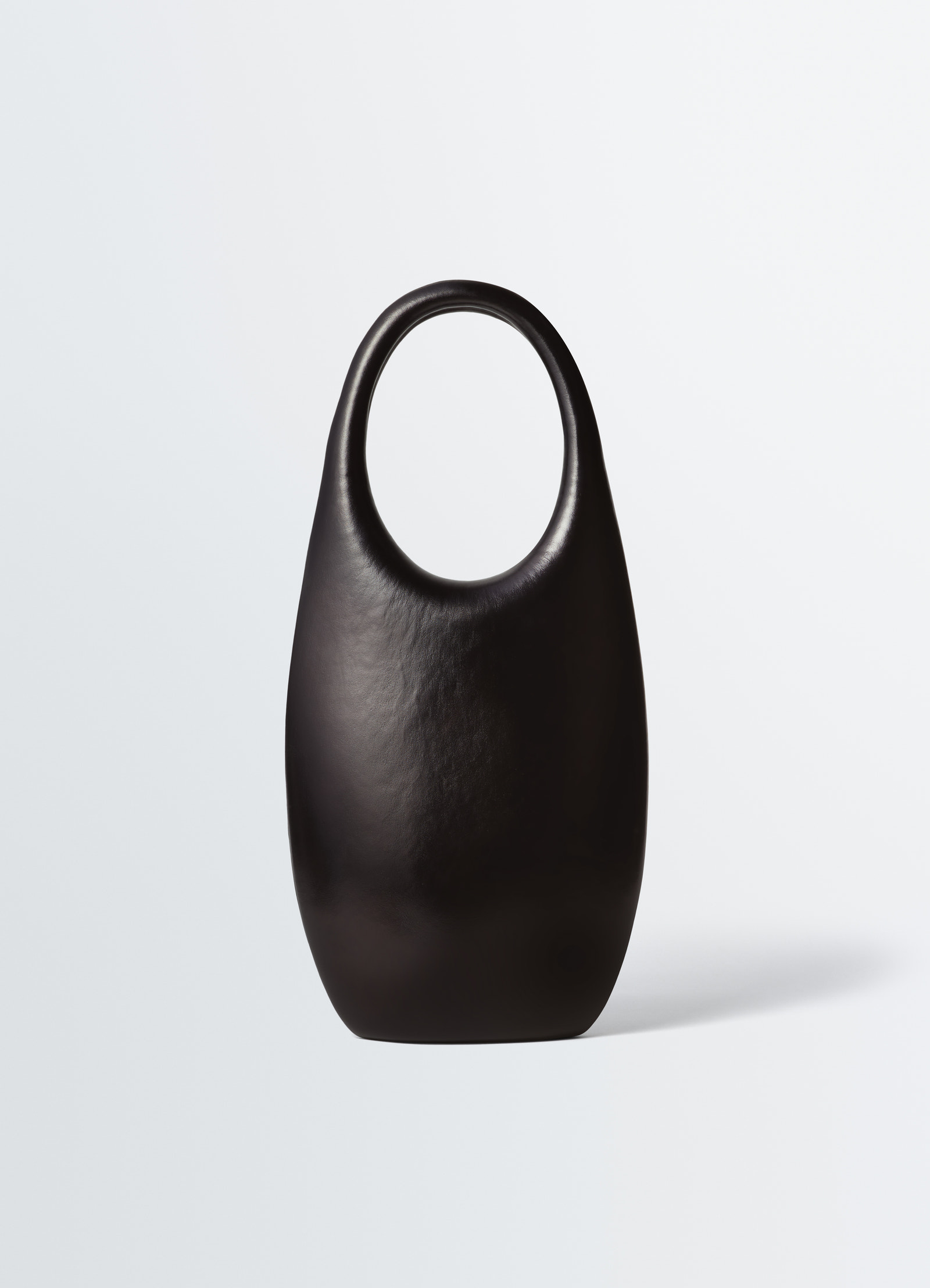 Carlos peñafiel black leather naho bag with rounded handles by lemaire on plain white background
