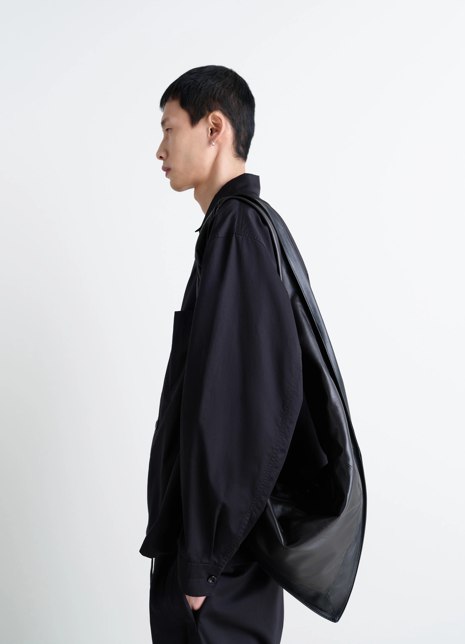 Lemaire small scarf extended handle in black nappa leather, model shot, profile view single shoulder carry