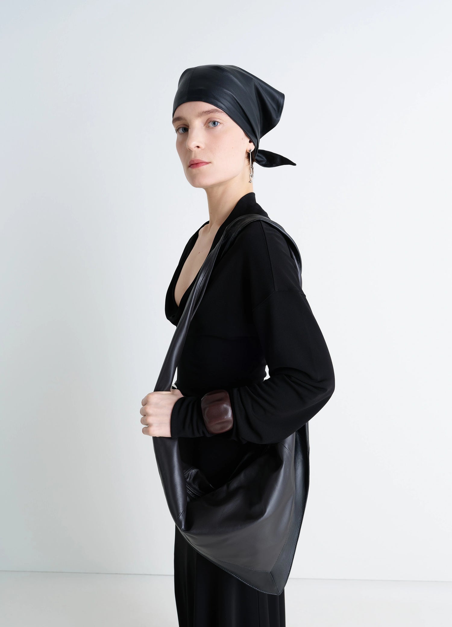 Lemaire Small Scarf Extended Handle in Black Nappa Leather, model shot, Side view Twisted shoulder strap