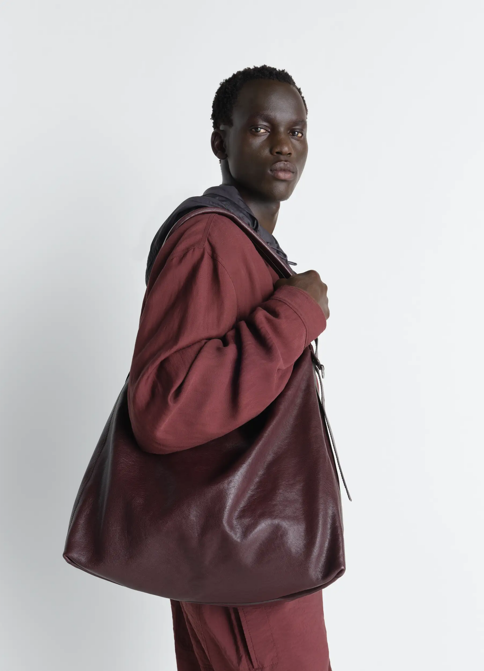 Belted hobo bag in leather in glazed paper leather, model shot, side view casual draped look