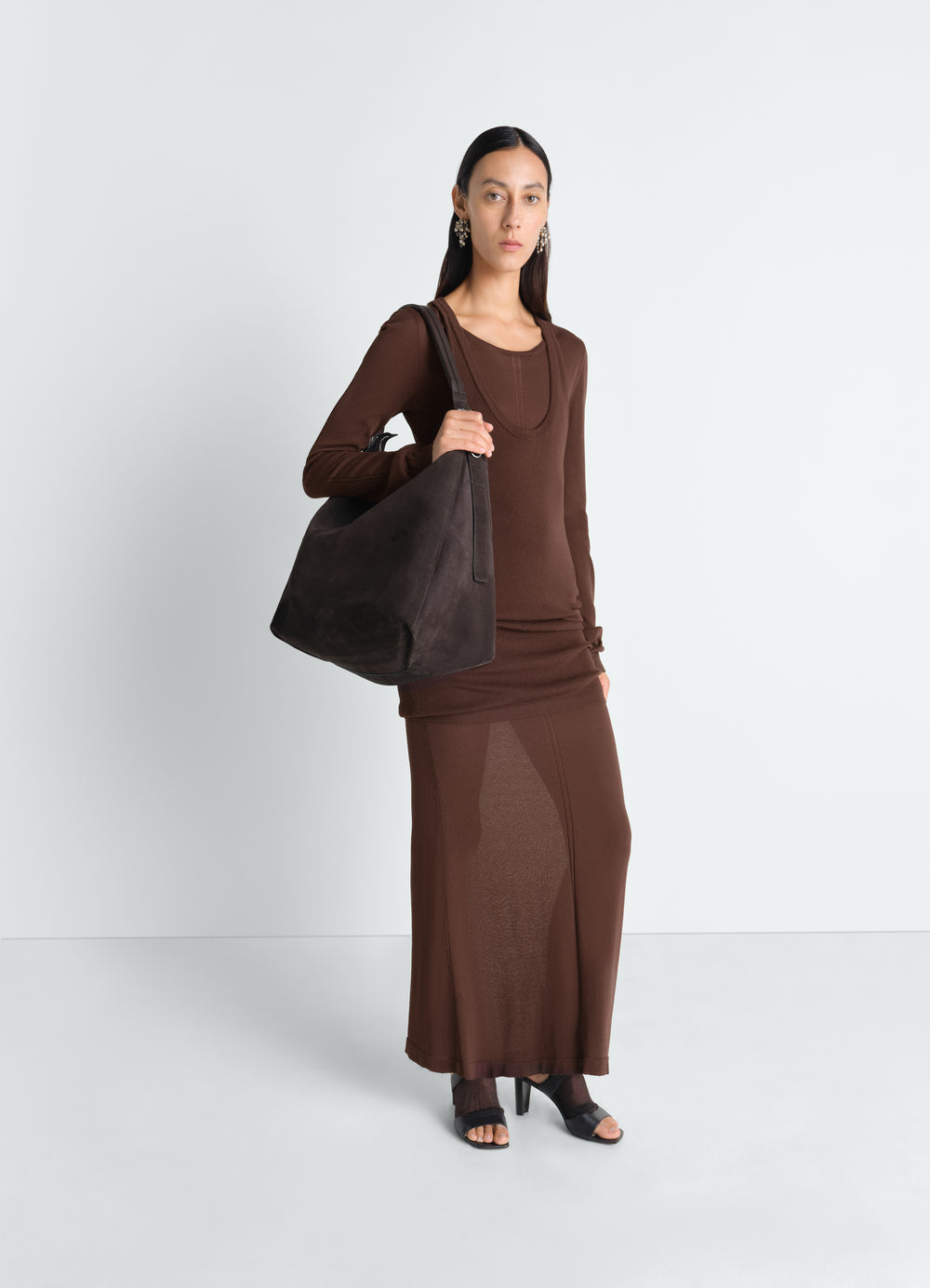 Belted hobo bag in dark brown suede leather LEMAIRE worn by model with brown knit dress front view