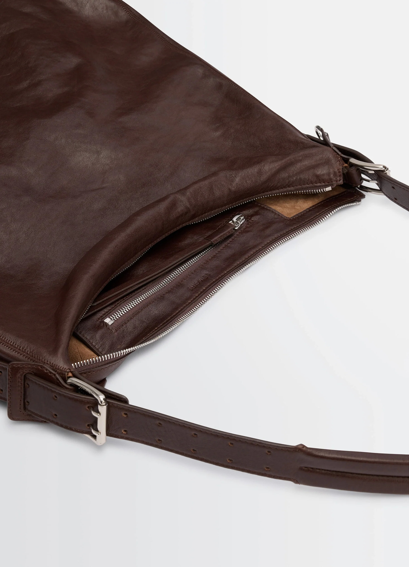 Belted hobo bag in glazed paper leather, product shot, top zipper detail adjustable belt strap
