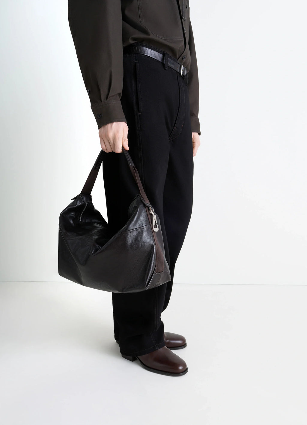 Berlingot Hobo Bag in Glazed Paper Leather, model shot, hand-held perspective glossy finish visible