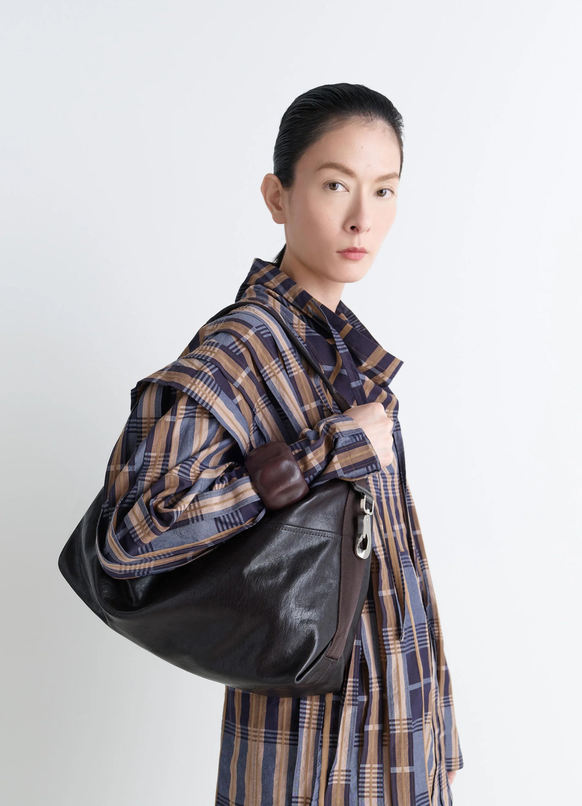 Berlingot Hobo Bag in Glazed Paper Leather, model shot, Side view Metal side snap hook