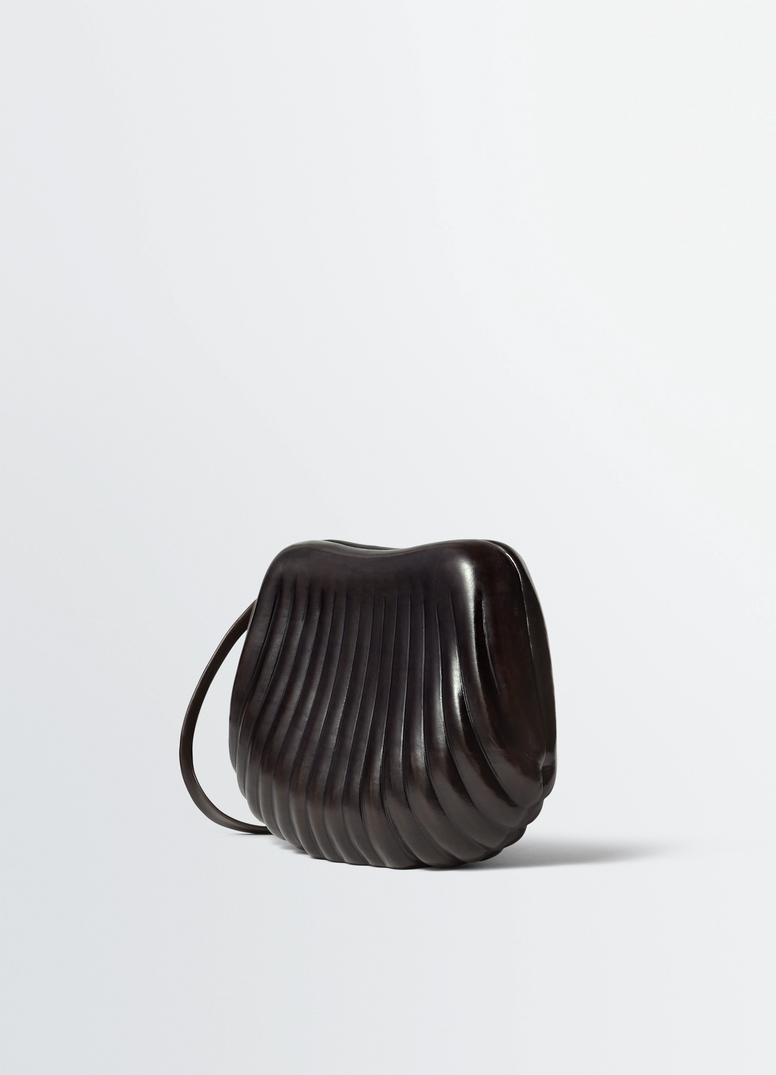 Carlos bag in molded leather in patinated vegetable-tanned leather, product shot, angled back view ribbed texture details
