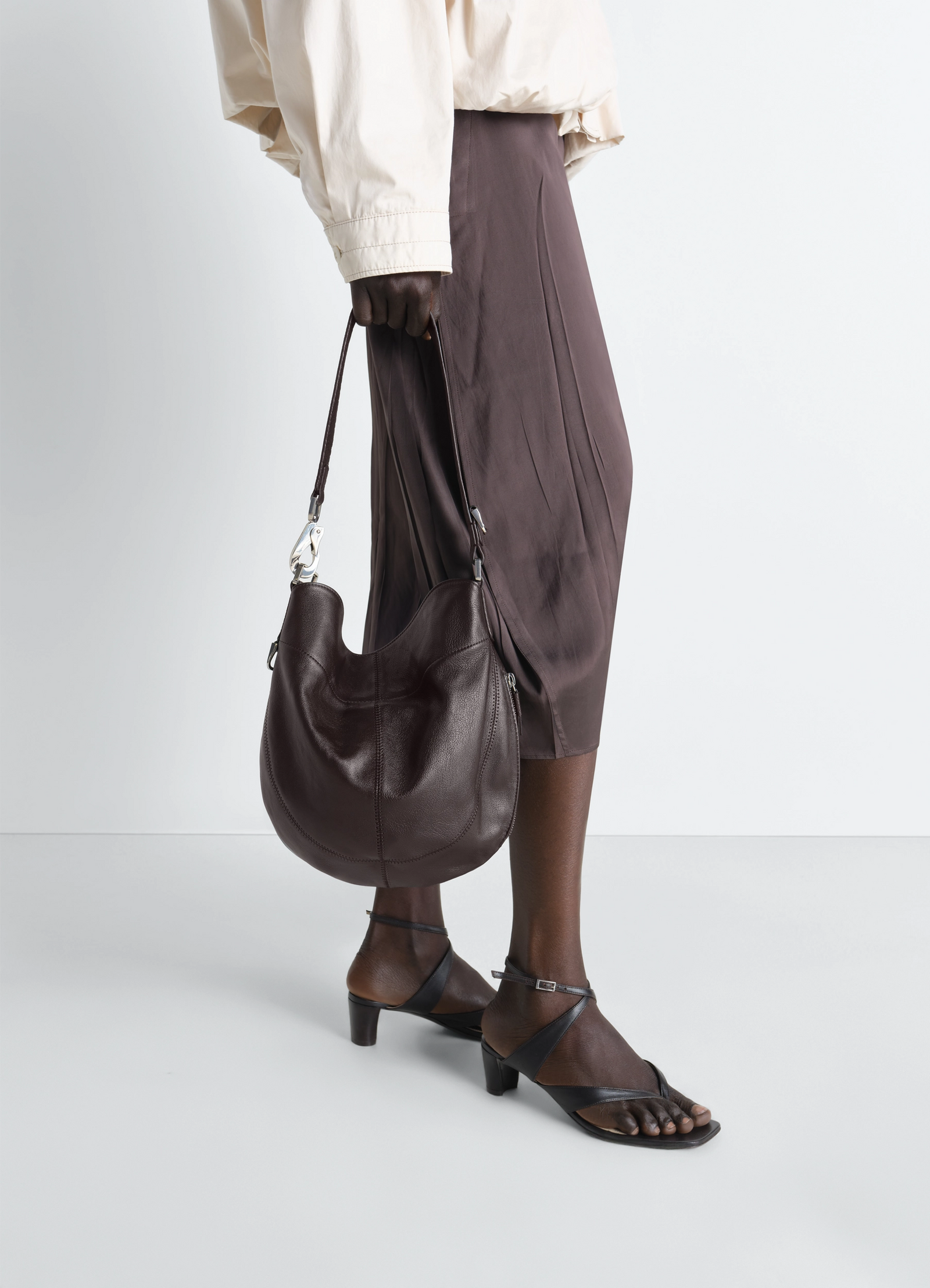 Hobo quiver clip bag in leather in grained buffalo leather, model shot, side view hanging strap detail