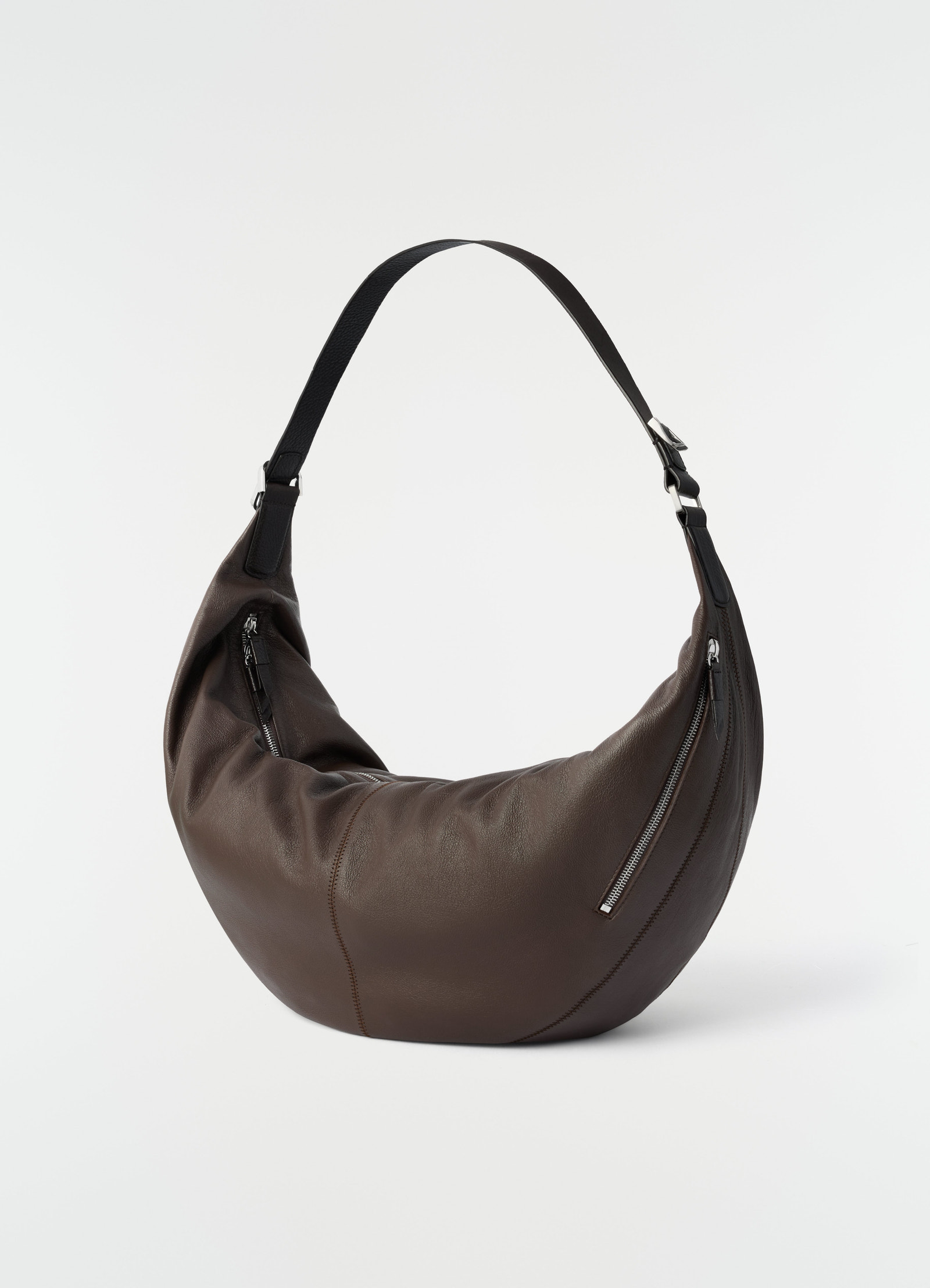 Large brown leather quiver clip bag by lemaire with black strap and silver zippers on plain white background