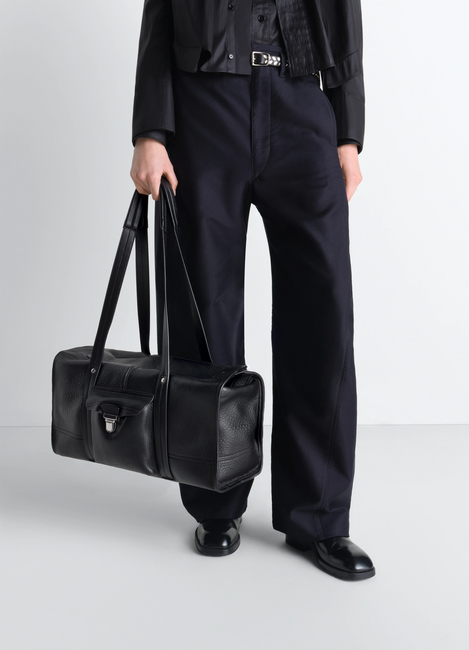 Lemaire soft gear tote bag in black bubble leather, model shot, bottom view held by model