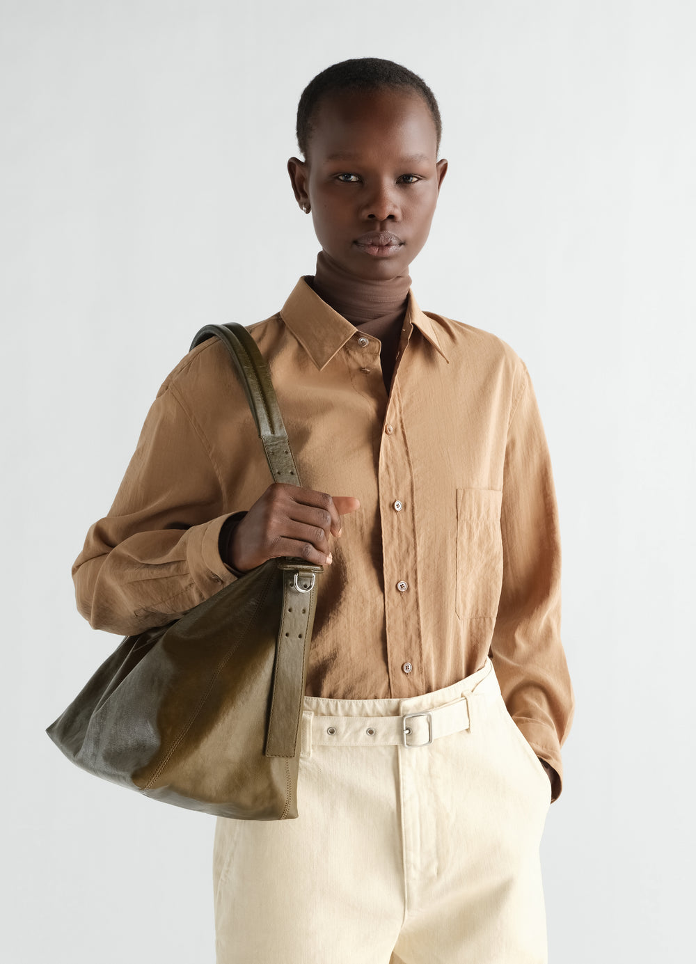 Sac belted hobo petit modèle en cuir, coloris olive, porté par un mannequin, vue de face, ceinture visible