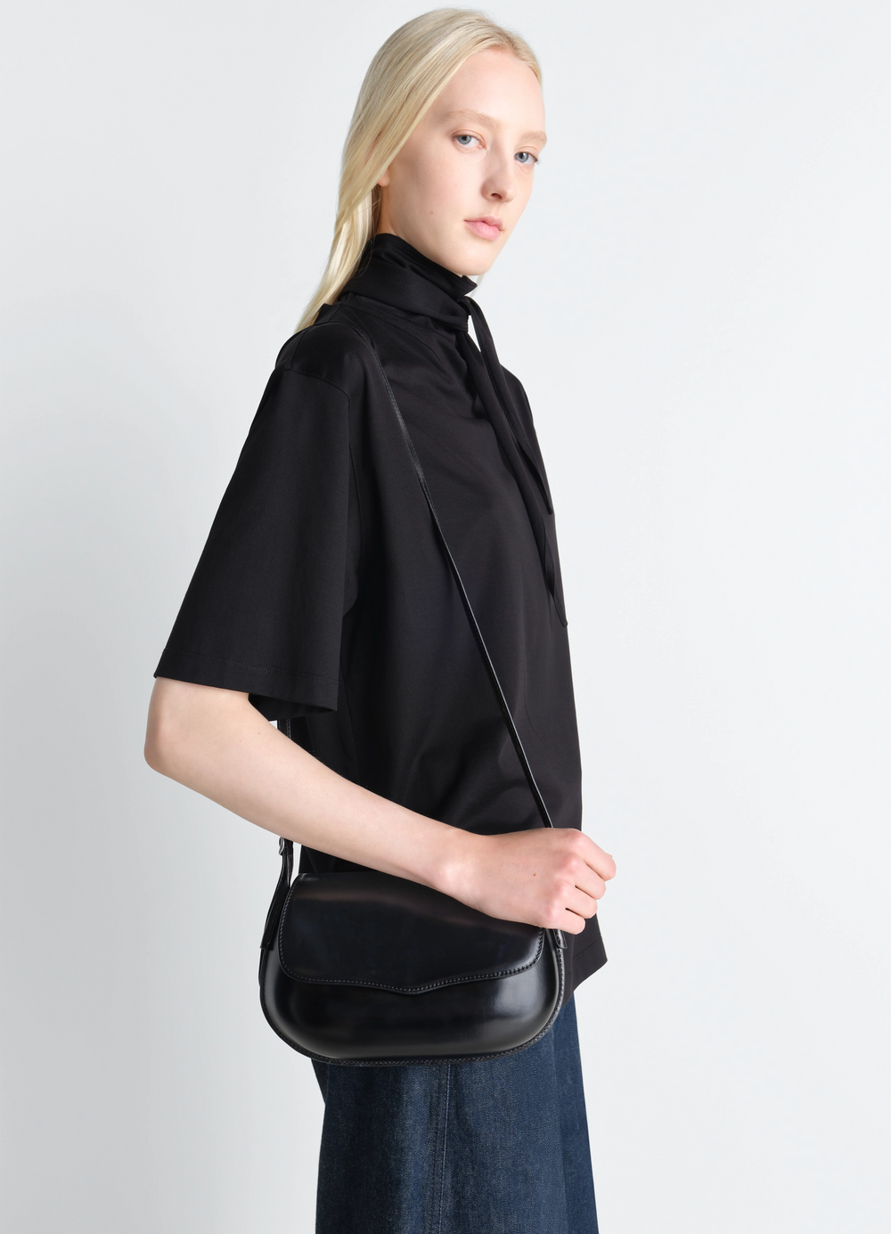 Lemaire Belly Bag in Silver LWG-certified leather, model shot, side view curved silhouette