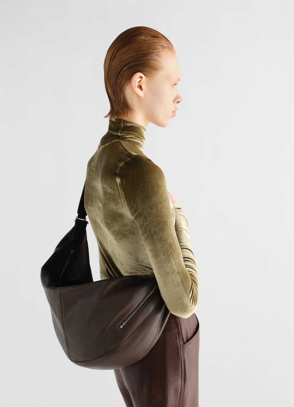 Sac Quiver clip en cuir, coloris marron foncé, porté par un mannequin, vue de profil