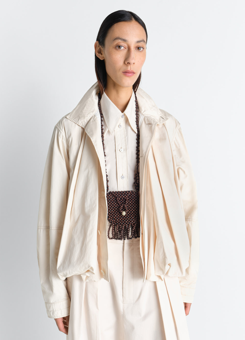 Grigri Necklace Bag in Wooden Beads, model shot, worn by model dark brown fringe