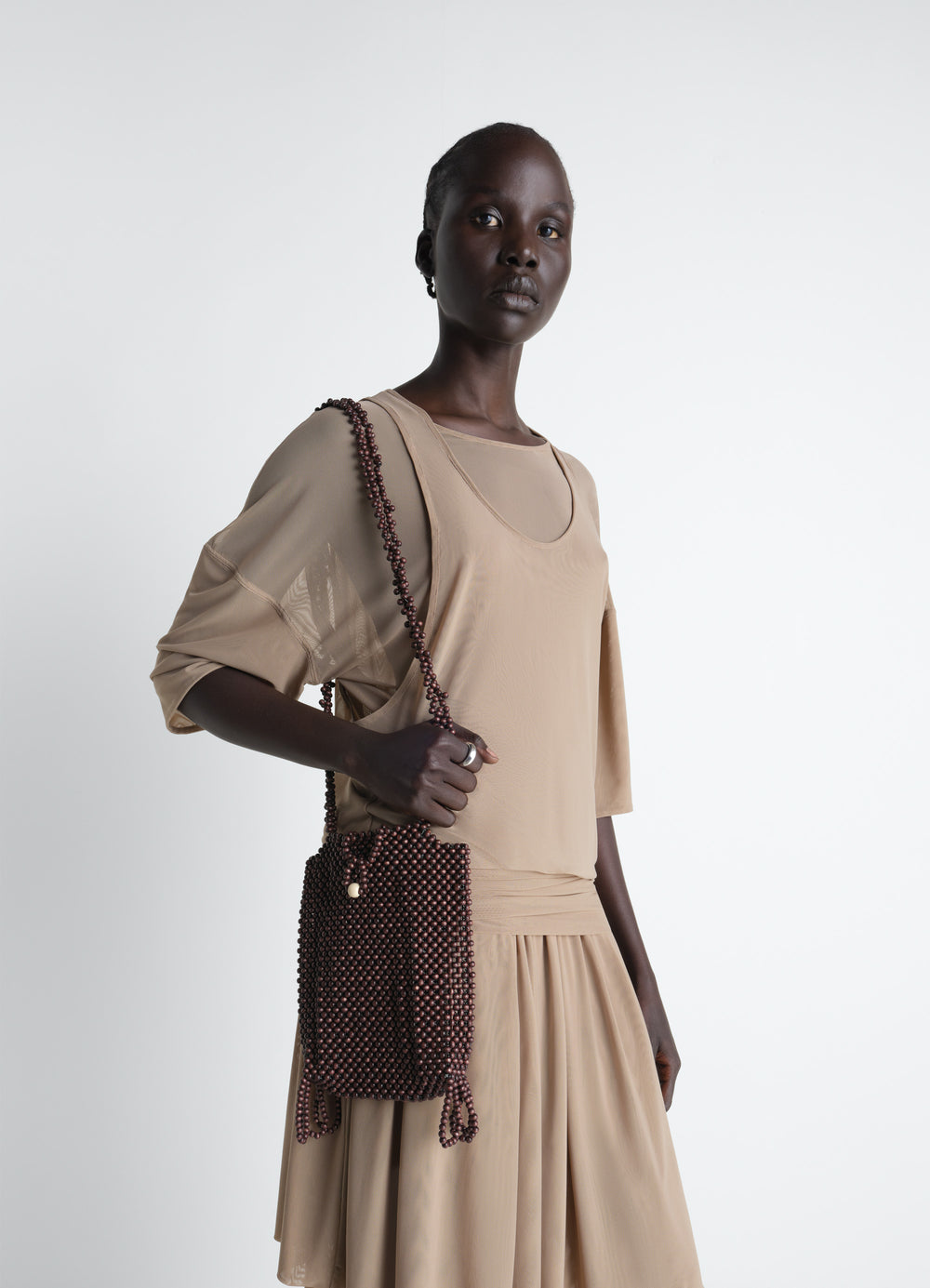 Lemaire Grigri Phone Holder in Wooden Beads, model shot, side view corded shoulder strap