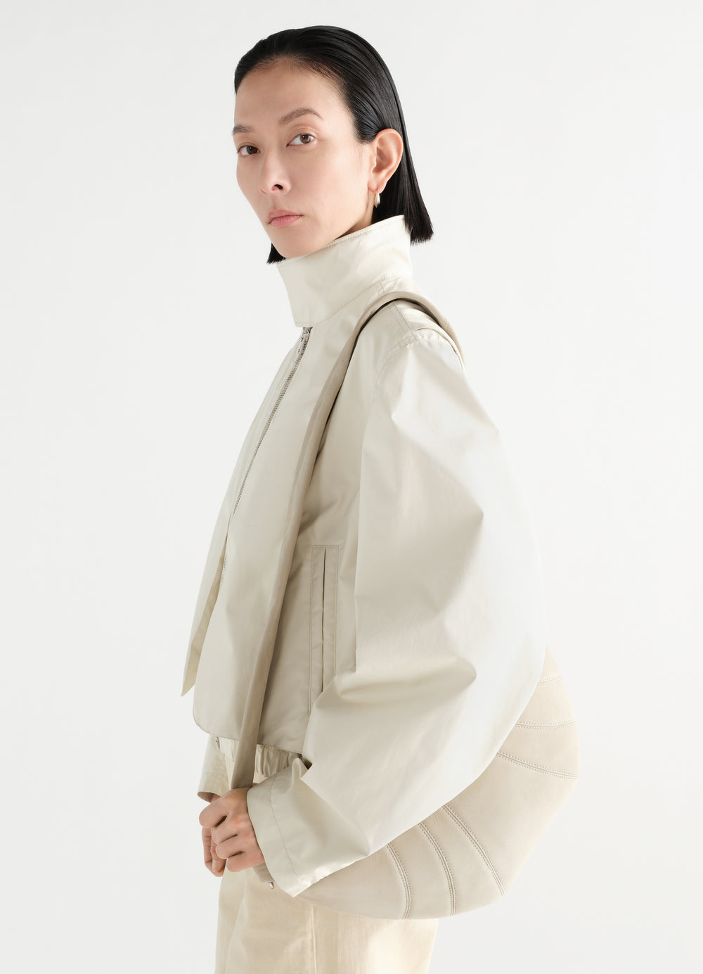 Medium Croissant Bag LEMAIRE in beige alpaca nubuck worn by model side view with cream jacket on white background