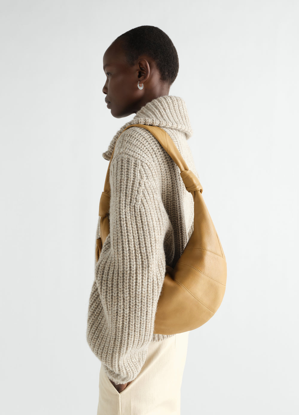 Sac Fortune Croissant en cuir de chèvre, coloris moutarde, porté par un mannequin, vue de profil