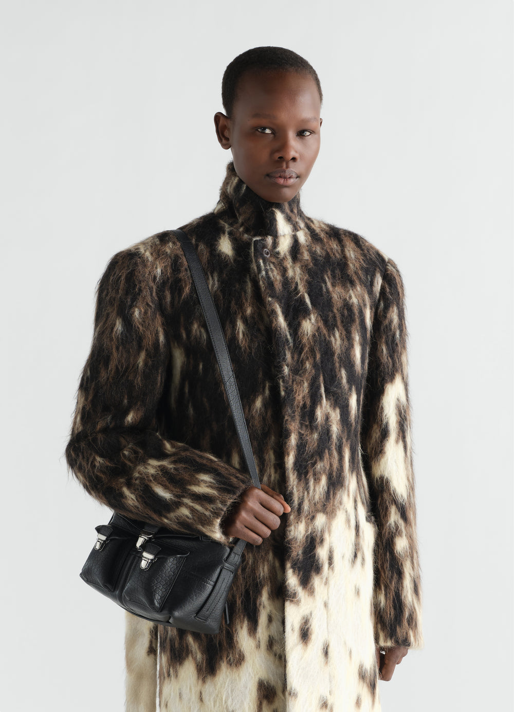 Mini Soft Gear Bag in black lambskin with silver buckles worn by model LEMAIRE front view