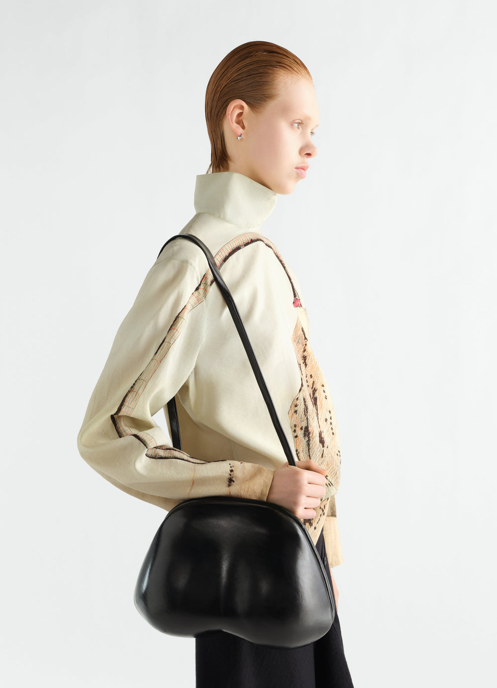 Sac Fesses en cuir patiné, coloris noir, porté par un mannequin, vue de profil