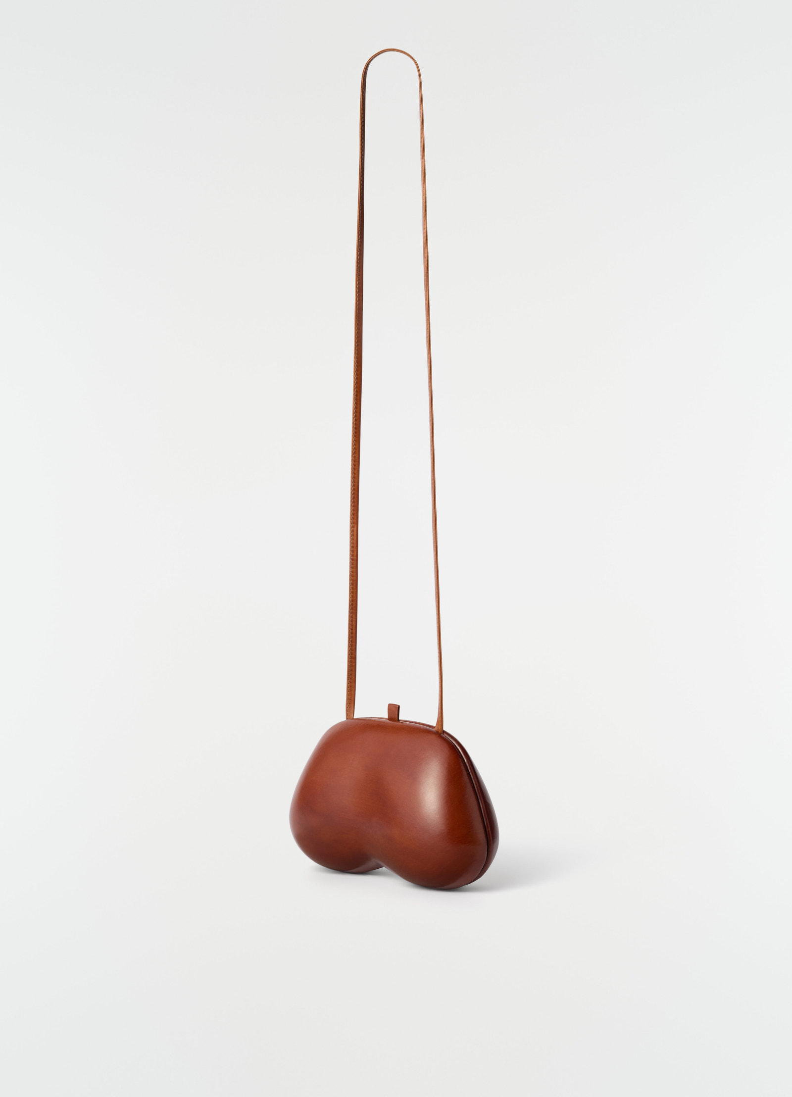 Fesses clutch in brown patinated calfskin leather with long strap by lemaire on plain white background