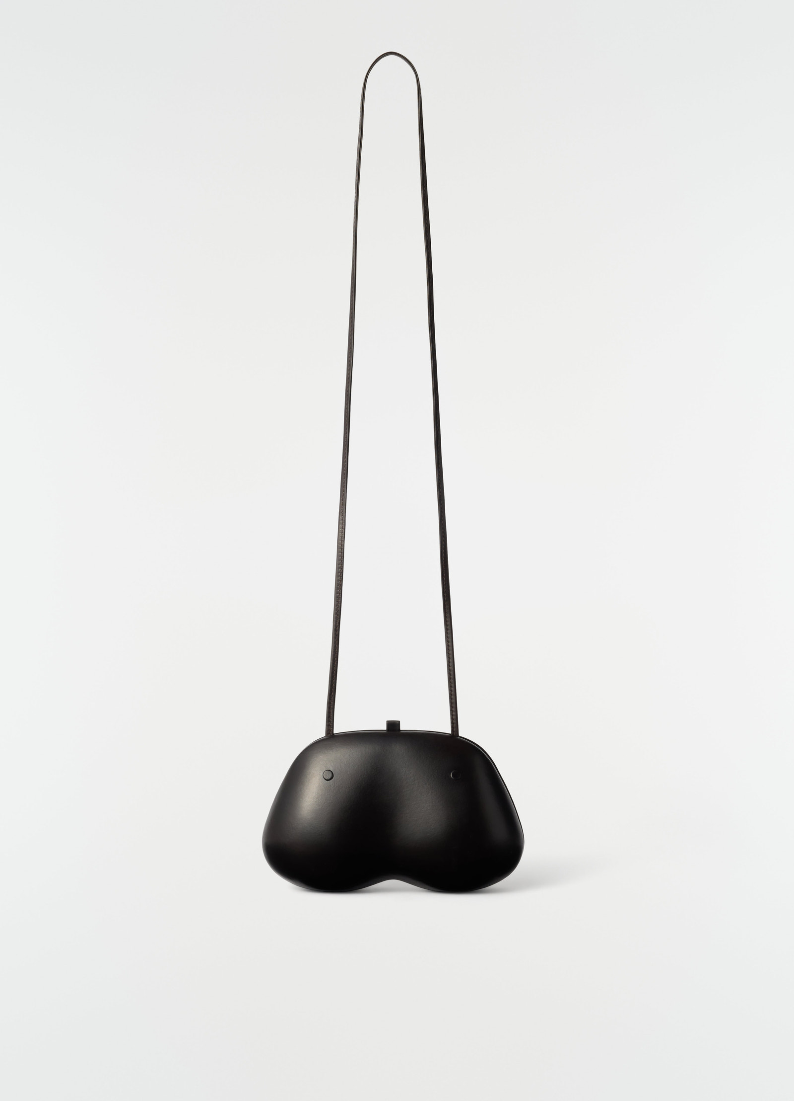 Fesses clutch bag in black patinated calfskin with long strap by lemaire front on white background