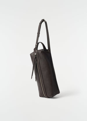 Care shoulder bag in dark brown nappa lambskin with silver zip detail by lemaire side view on white background