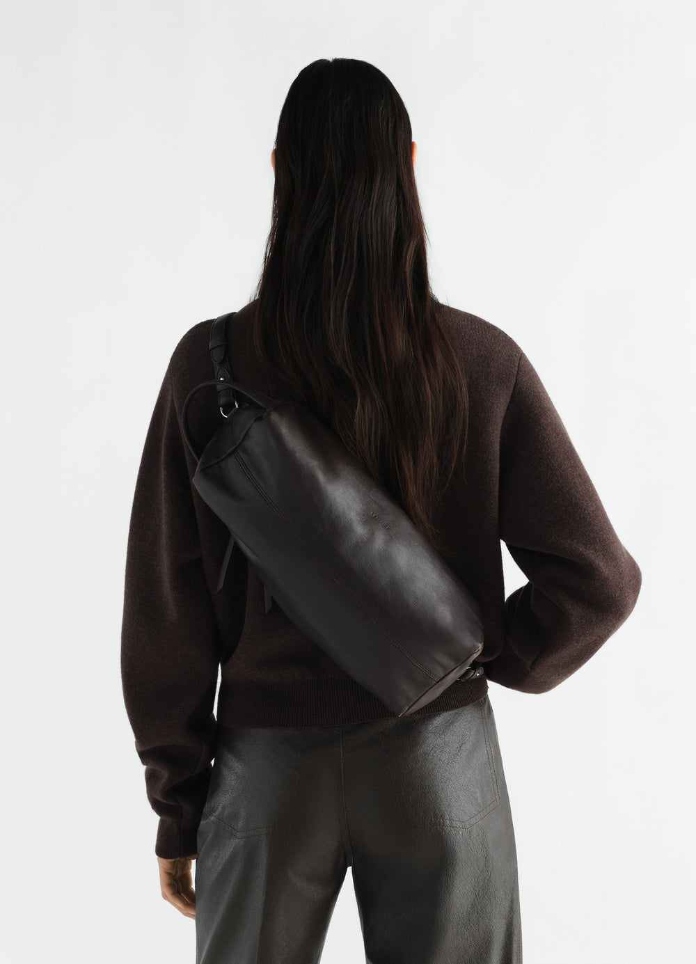 Care Shoulder Bag black nappa lambskin by LEMAIRE worn by model back view on white background