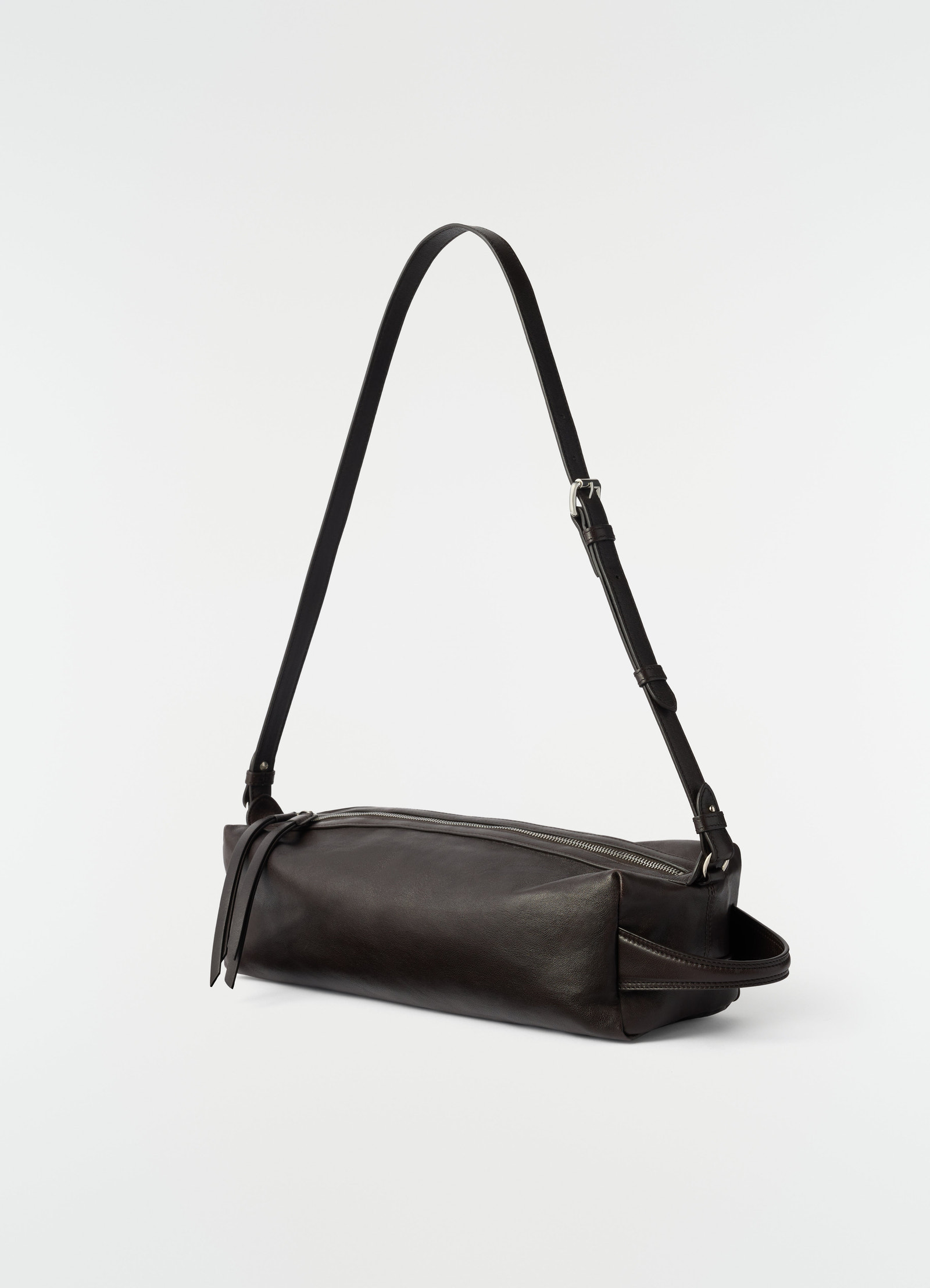 Care shoulder bag in black nappa lambskin with adjustable strap by lemaire on plain white background