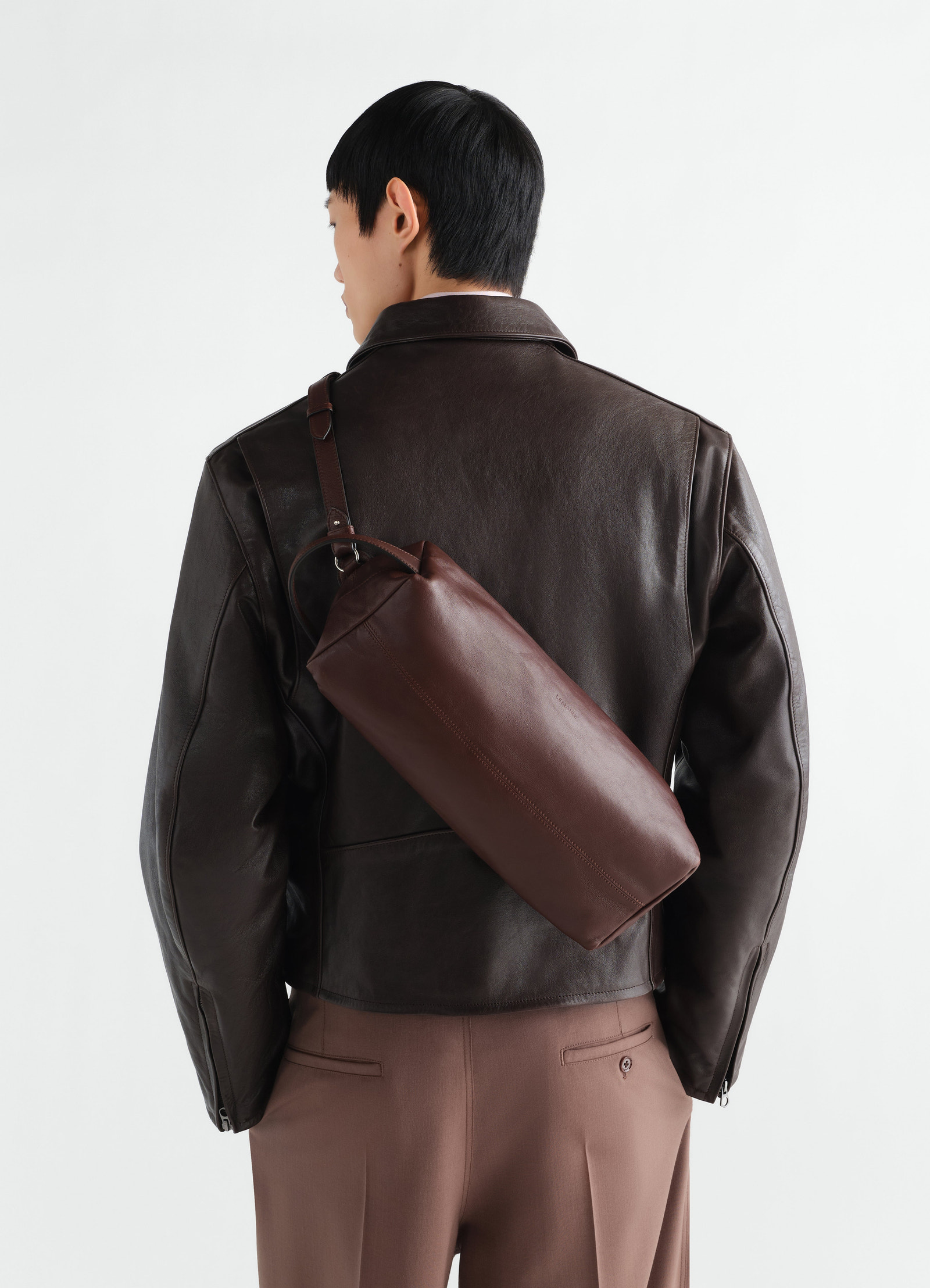 Care shoulder bag in dark brown nappa lambskin lemaire worn by model back view
