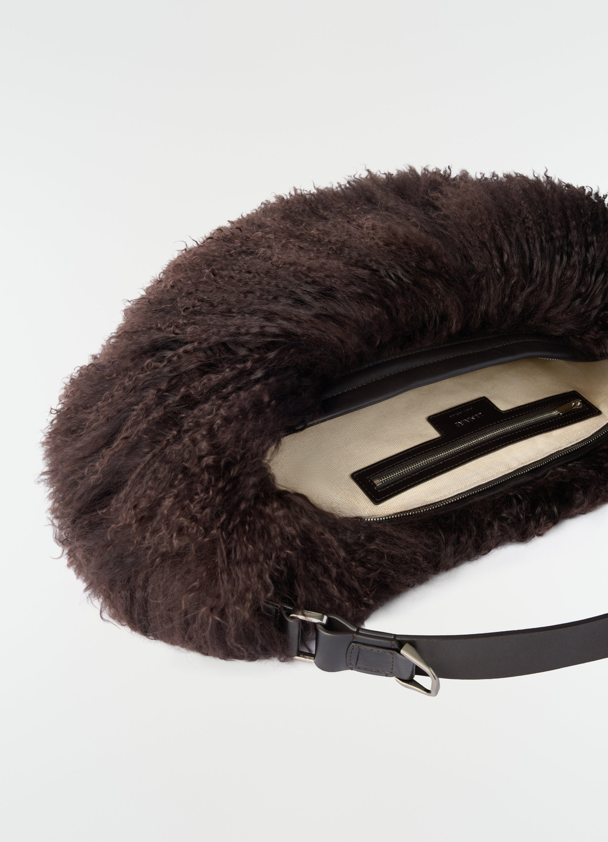 Quiver clip bag in dark brown mongolian lambskin with leather strap and open zipper, lemaire close-up detail
