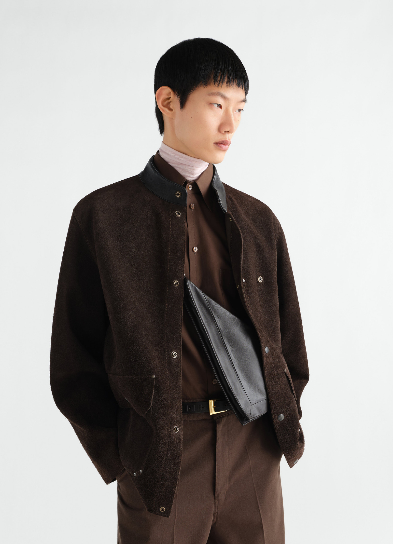 Pocket scarf bag in shiny black nappa lambskin by lemaire worn crossbody by a model with brown outfit