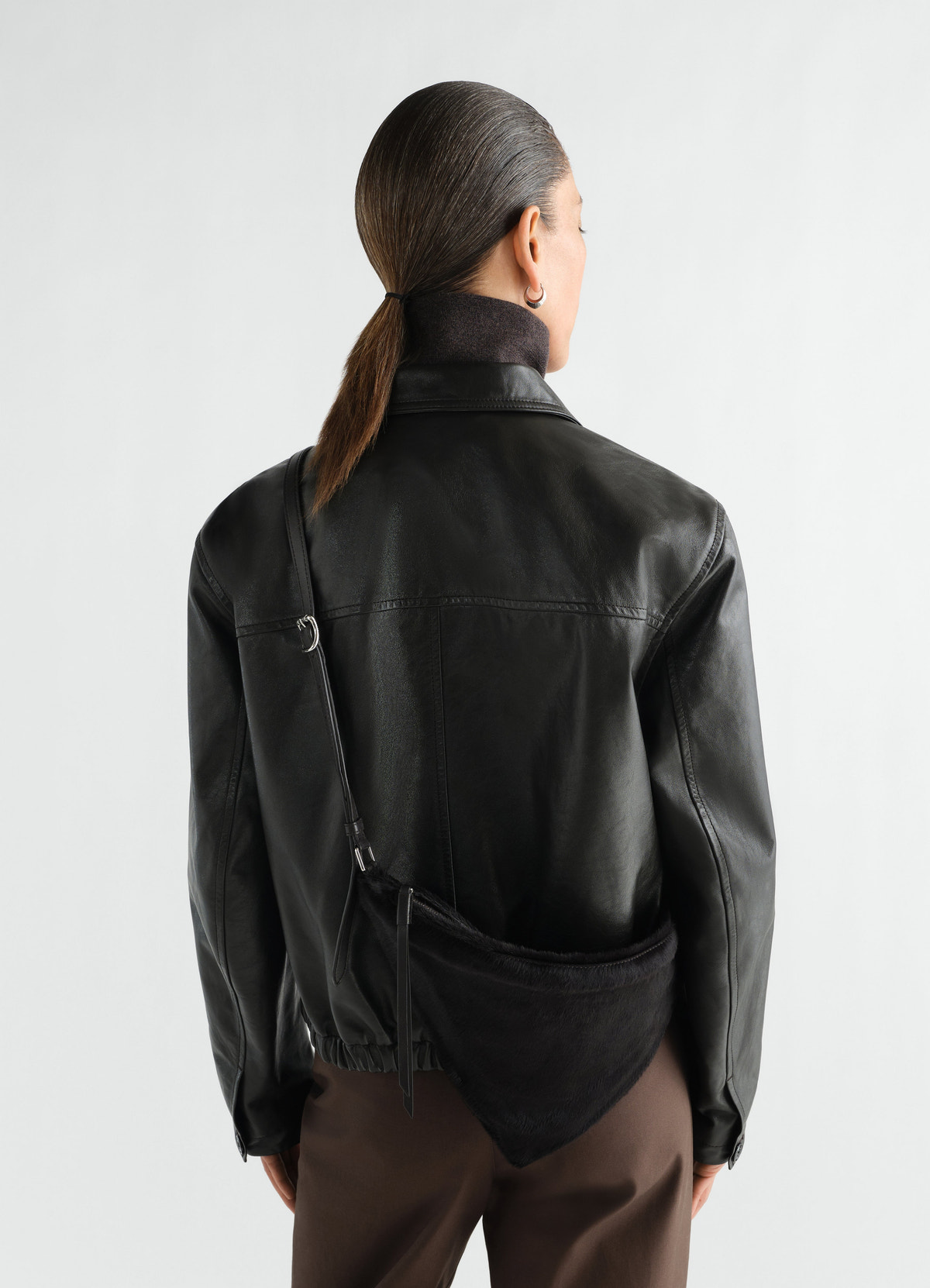 Pocket scarf bag lemaire black pony-style leather worn by a model back view with strap across shoulder