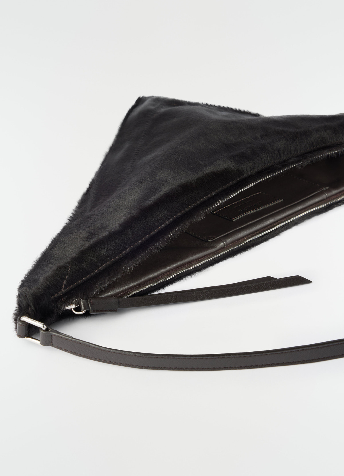 Pocket scarf bag in black pony-style leather with zip and leather strap by lemaire on white background close-up detail