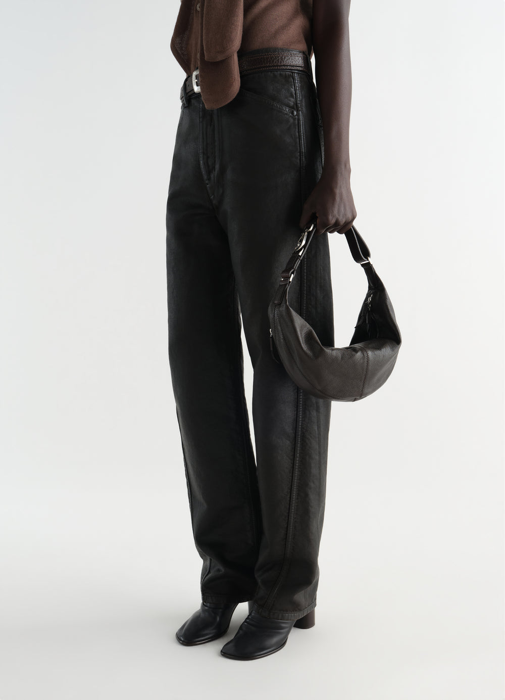 Mini Quiver Clip Bag in dark brown grained buffalo leather by LEMAIRE worn by model side view