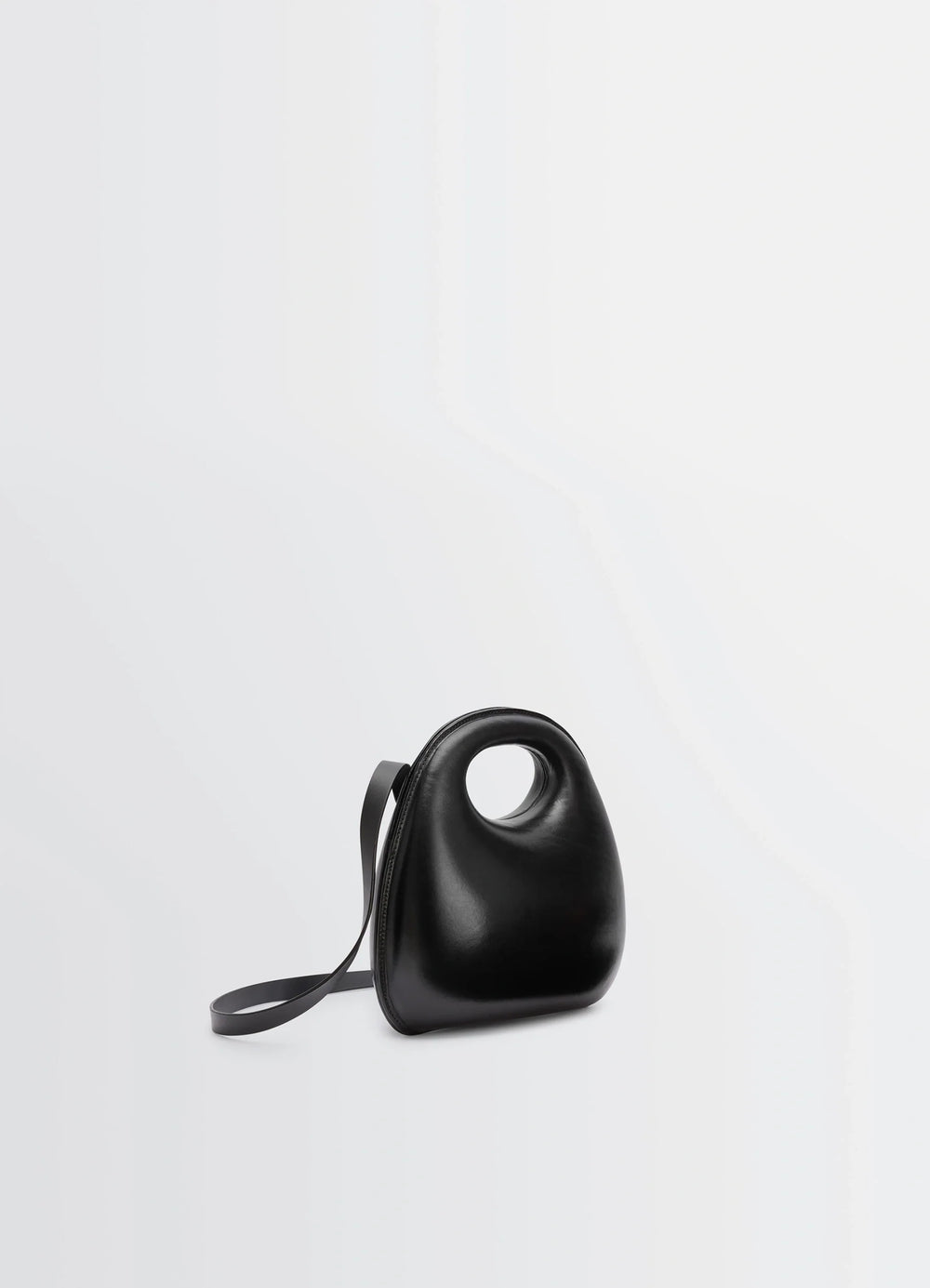 Lemaire Egg Bag in Black Patinated Leather, product shot, three-quarter view circular handle feature