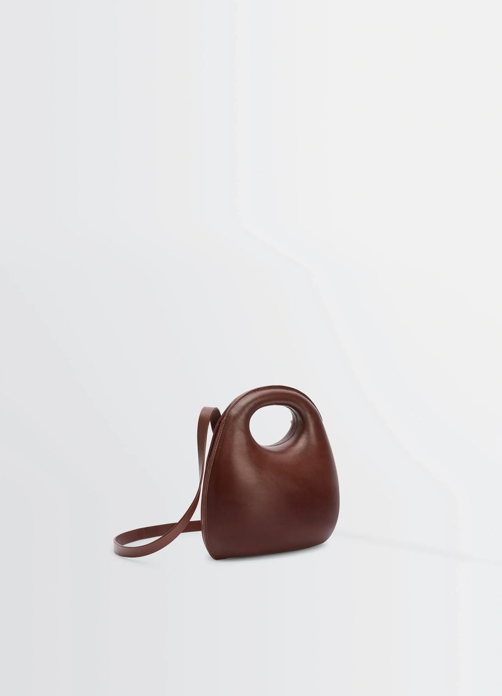 Lemaire Egg Bag in Patinated Leather Brown, product shot, side view integrated strap design
